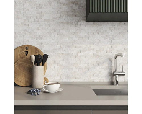 Scenă de bucătărie cu plăci de mozaic, chiuvetă, robinet, tocătoare, ustensile de bucătărie, cană și afine