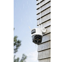 Cameră de supraveghere exterioară pe un perete de casă în ploaie