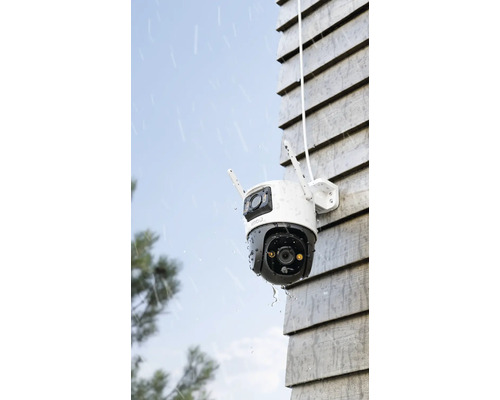 Cameră de supraveghere exterioară pe un perete de casă în ploaie