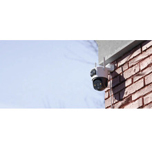 Cameră de securitate montată la exterior pe un zid de cărămidă