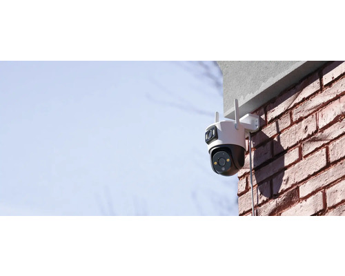 Cameră de securitate montată la exterior pe un zid de cărămidă