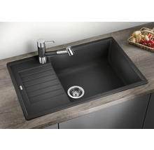 Chiuvetă de bucătărie neagră cu zonă de scurgere și robinet pe un blat