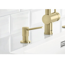 Dozator de săpun auriu lângă un robinet pe o chiuvetă.