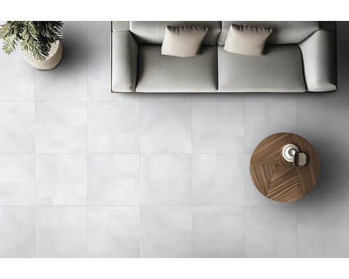 Interior cu gresie albă, canapea și masă