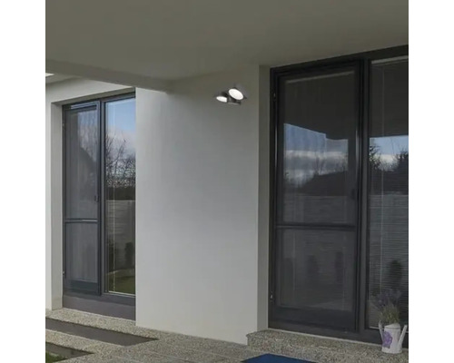 Exteriorul unei case cu iluminat de fațadă și ferestre