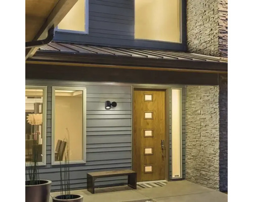 Zona de intrare a unei case cu ușă de intrare, fereastră și corp de iluminat exterior.