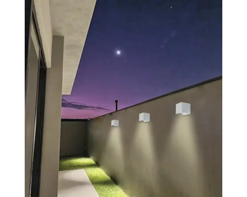 Scenă cu trei lămpi de perete pătrate pe un zid exterior la amurg