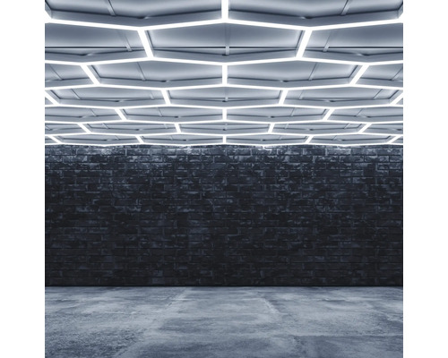 Interior cu perete de cărămidă, podea de beton și iluminat hexagonal de tavan