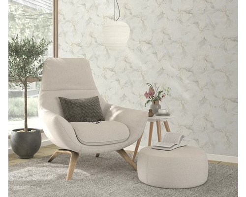 Cameră de zi cu fotoliu, taburet, măsuță laterală, plantă de apartament și tapet cu model