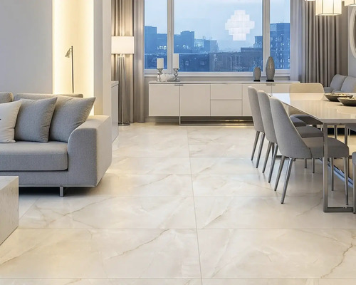 Cameră de zi luminoasă cu canapea, masă de sufragerie și gresie cu aspect de marmură.