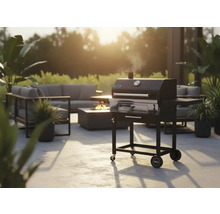 Scenă de grădină cu grătar pe cărbune, zonă de relaxare și focar pentru o atmosferă confortabilă în aer liber.