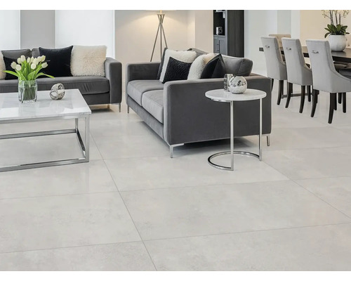 Living cu podea deschisă la culoare, canapele gri și masă de sufragerie cu scaune.