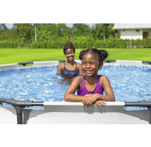 Două femei într-o piscină supraterană în grădină.