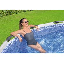 Femeie relaxându-se în piscină în grădină