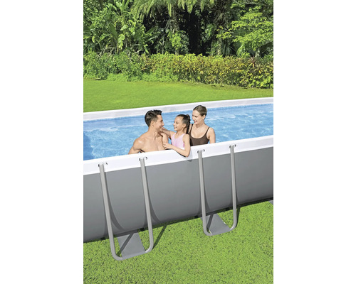 Familie în piscină supraterană în grădină