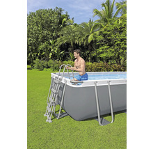 Bărbat care intră într-o piscină dreptunghiulară cu cadru de oțel într-o grădină folosind o scară