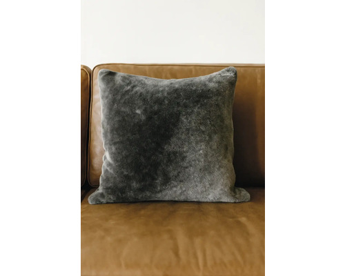 Pernă decorativă din blană artificială pe o canapea