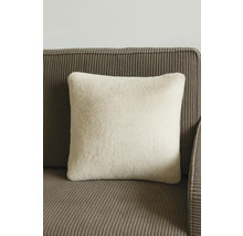 Pernă pătrată din imitație de blană pe o canapea