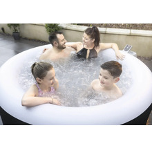 Familie se relaxează într-un jacuzzi gonflabil în grădină.