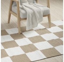 Covor cu model de tablă de șah sub un fotoliu cu pătură