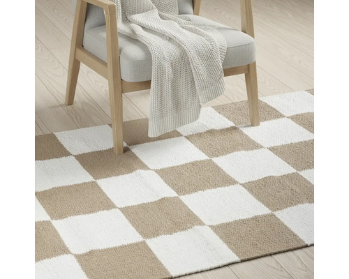 Covor cu model de tablă de șah sub un fotoliu cu pătură