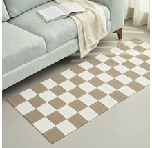 Fotografie de interior a unui living cu o canapea și un covor cu model de tablă de șah