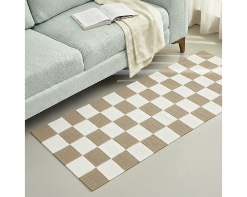 Fotografie de interior a unui living cu o canapea și un covor cu model de tablă de șah