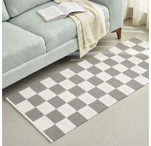 Covor cu model de tablă de șah în fața unei canapele