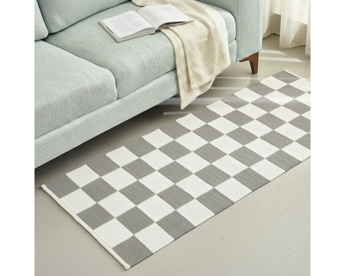 Covor cu model de tablă de șah în fața unei canapele