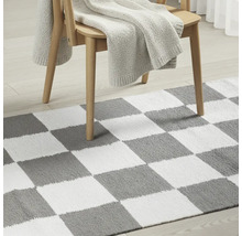 Covor cu model de tablă de șah sub scaun de lemn cu pătură