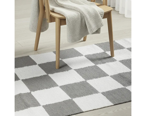 Covor cu model de tablă de șah sub scaun de lemn cu pătură