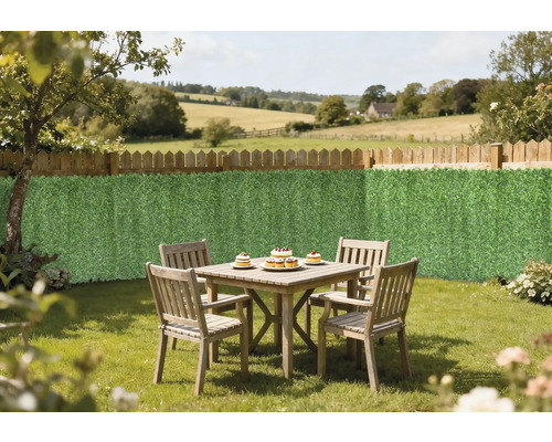 Scenă de grădină cu gard din lemn, covoraș de intimitate și o masă din lemn cu patru scaune în grădină