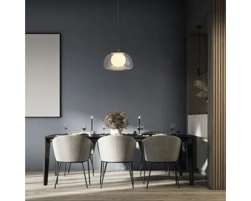 Masa de sufragerie cu lampă suspendată, scaune și decorațiuni într-o cameră luminoasă.