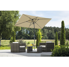 Scenă de grădină cu set de mobilier din ratan, compus din fotolii, masă și o umbrelă de soare dreptunghiulară