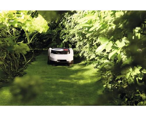 Robot de tuns iarba într-o grădină verde