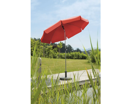 Umbrelă de soare roșie în grădină pe terasă de lemn