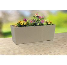 Jardinieră bej cu flori galbene și roz pe o masă