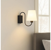 Lumină de perete cu abajur din material textil și suport metalic în dormitor