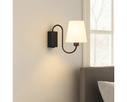 Lumină de perete cu abajur din material textil și suport metalic în dormitor