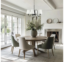 Sufragerie cu masă rotundă din lemn, scaune, candelabru și șemineu.