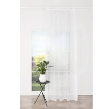 Cameră luminoasă cu draperie albă transparentă și plantă de apartament pe o măsuță laterală