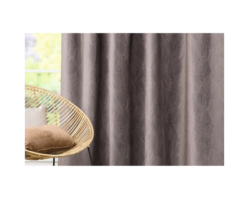 Cortină decorativă cu model de frunze lângă un fotoliu din răchită