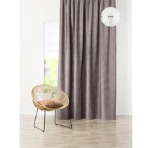 Șaluri decorative cu model lângă o fereastră și un fotoliu