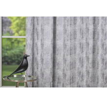 Cortină decorativă cu model abstract, completată de o statuie a unei păsări pe o masă