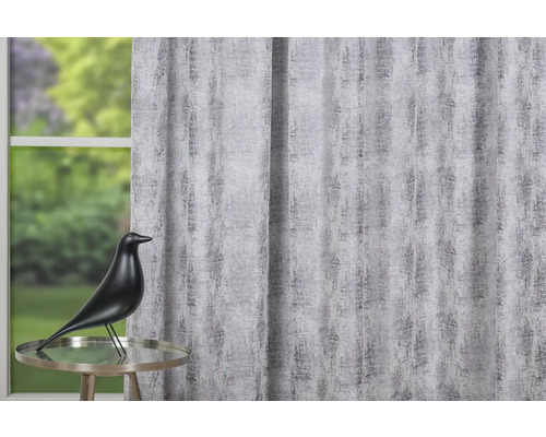 Cortină decorativă cu model abstract, completată de o statuie a unei păsări pe o masă