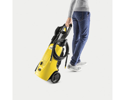 Persoană care transportă un curățător cu presiune Kärcher