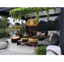 Terasa cu mobilier de lounge, vatră, lampă suspendată și plante sub o pergolă