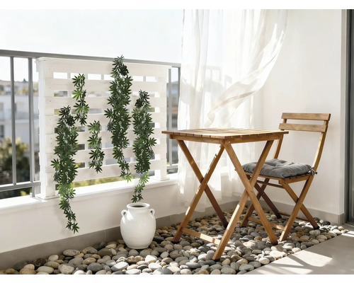 Balcon cu masă de lemn, scaun cu pernă, plante și paravan de intimitate