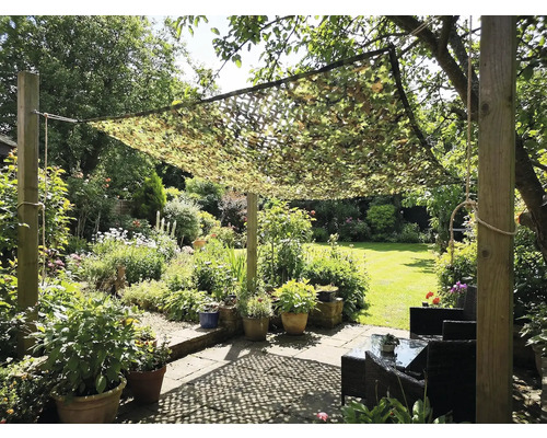 Grădină cu plasă de camuflaj ca protecție solară deasupra unei zone de relaxare