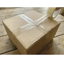 O cutie de carton este sigilată cu bandă adezivă transparentă.